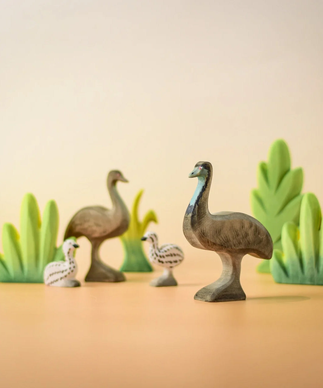 A family of Bumbu wooden emu's standing next to Bumbu decorative bushes.