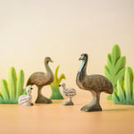 A family of Bumbu wooden emu's standing next to Bumbu decorative bushes.
