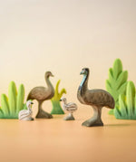 A family of Bumbu wooden emu's standing next to Bumbu decorative bushes.