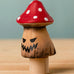 Bumbu handcrafted wooden enchanted mushroom decorative figure with painted spooky facial features and a red with white spots cap