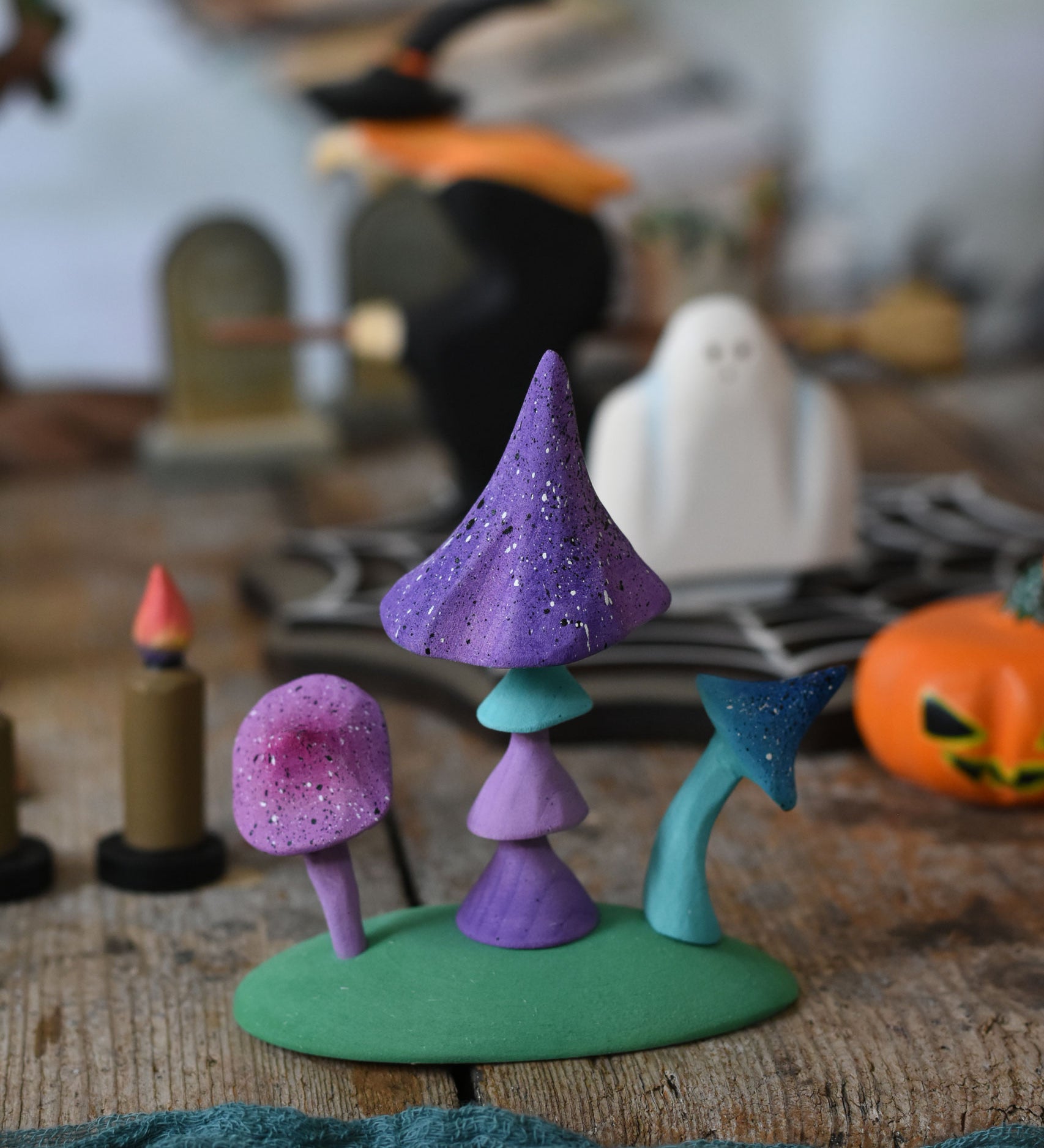 A set of Bumbu enchanted mushrooms placed at the front of a halloween small world play scene. These expertly hand crafted items are part of a large range of wooden toys available here at Babipur. 