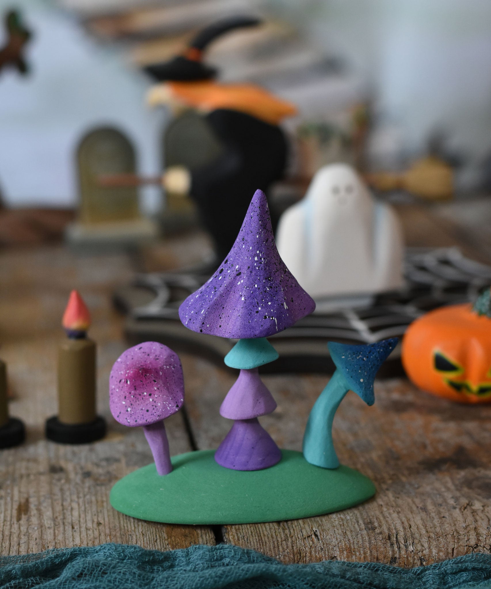 A set of Bumbu enchanted mushrooms placed at the front of a halloween small world play scene. These expertly hand crafted items are part of a large range of wooden toys available here at Babipur. 