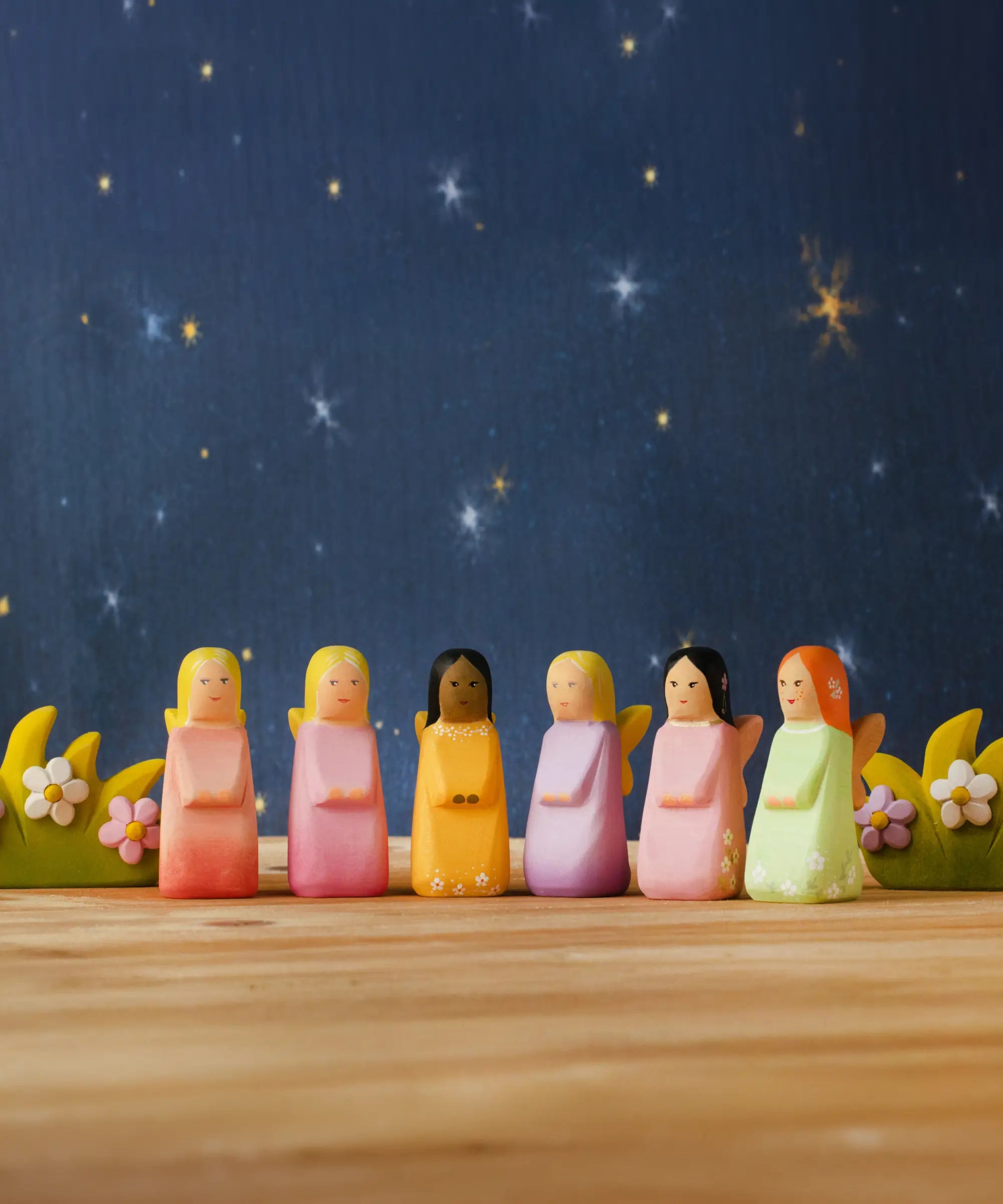 A nighttime display showing all Bumbu wooden fairy figures and blossom bushes