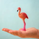 Bumbu toys handcrafted wooden pink standing flamingo figure in a hand showing scale