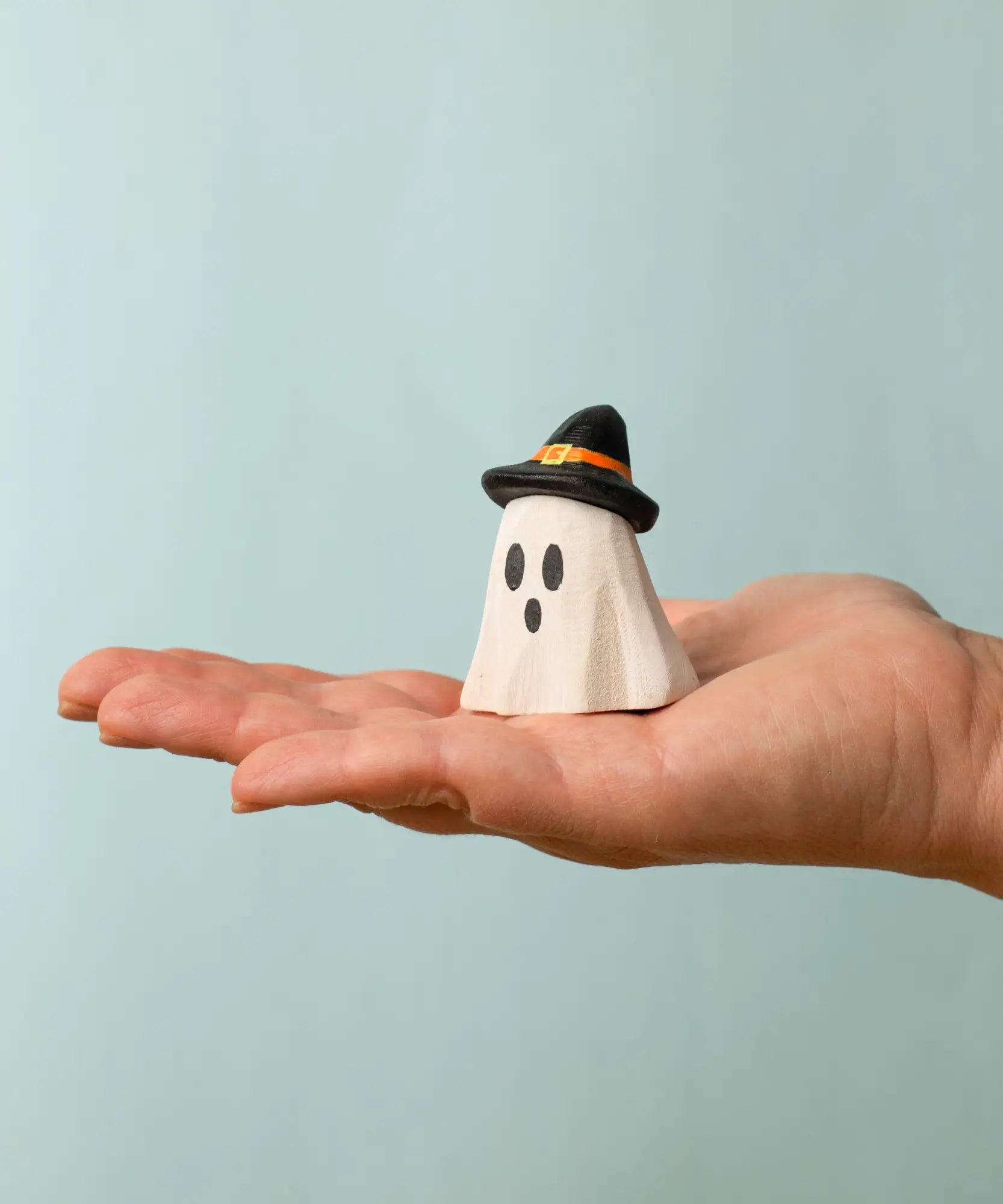 Bumbu wooden ghost wizard decorative figure standing on a adult hand showing scale 
