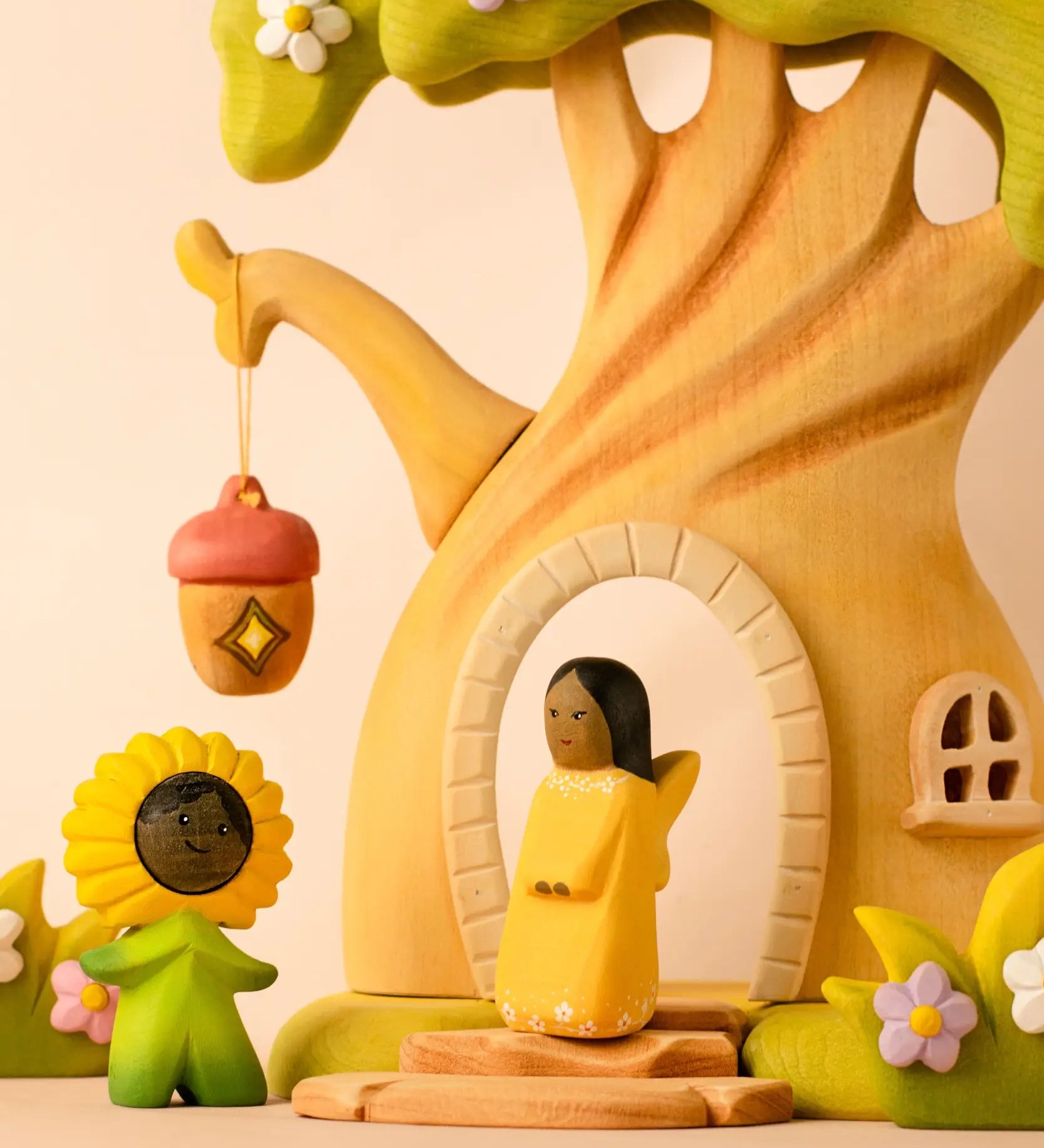Bumbu wooden golden fairy figure standing in front of a fairy treehouse next to a daisy flower child figure
