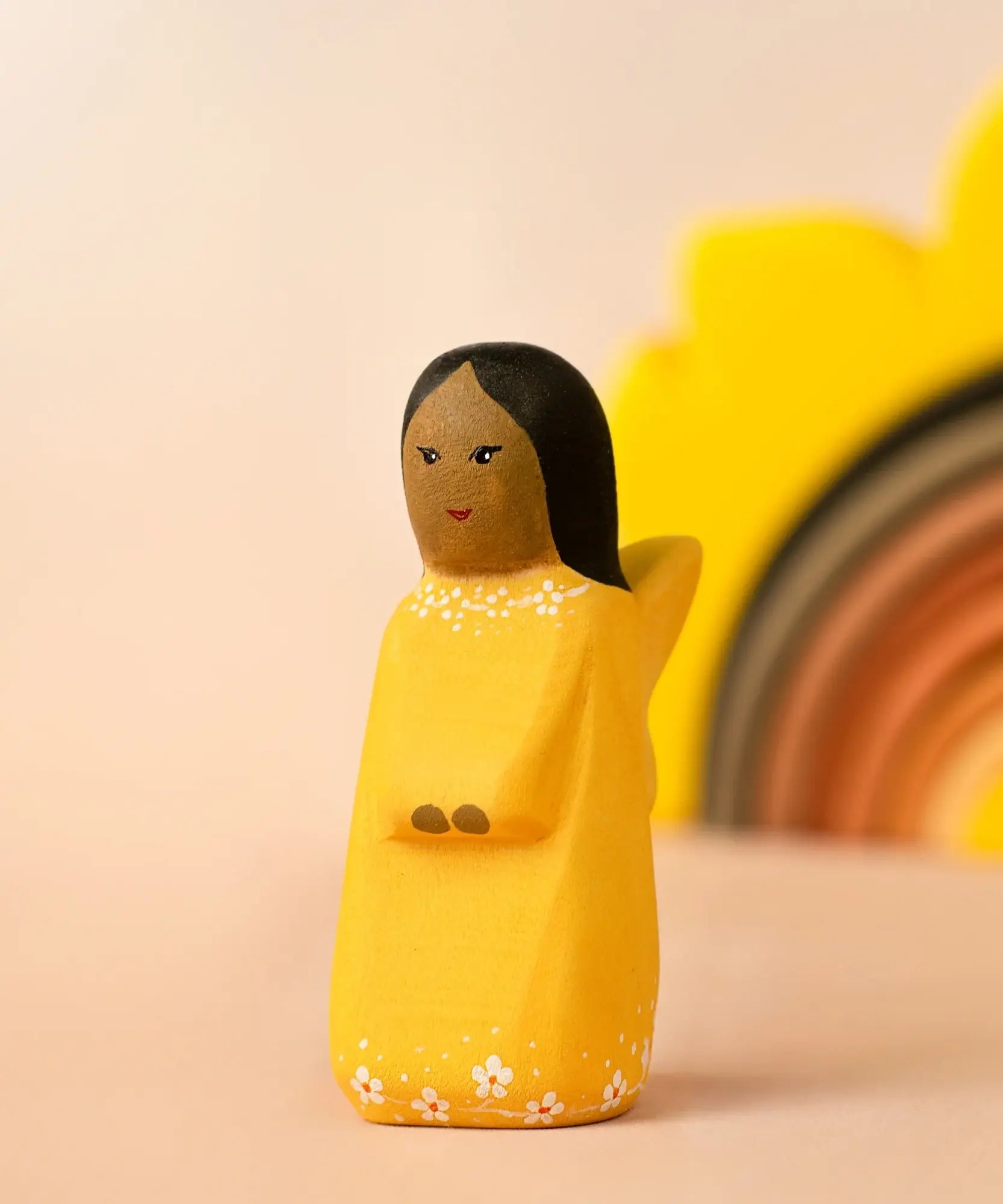 Bumbu wooden golden fairy figure with a sun stacker in the background.