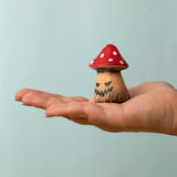 Bumbu handcrafted wooden enchanted mushroom decorative figure on an adult hand showing scale