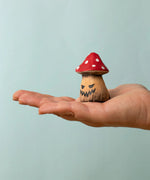 Bumbu handcrafted wooden enchanted mushroom decorative figure on an adult hand showing scale