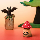 Bumbu handcrafted wooden enchanted mushroom decorative figure in a halloween display including a small spooky tree and a bat figure