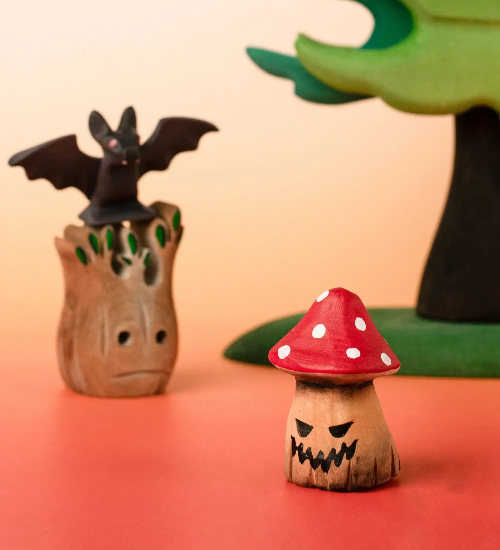 Bumbu handcrafted wooden enchanted mushroom decorative figure in a halloween display including a small spooky tree and a bat figure