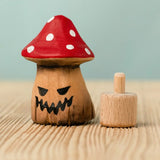 Bumbu handcrafted wooden enchanted mushroom decorative figure next to a celebration ring peg base