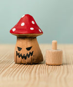 Bumbu handcrafted wooden enchanted mushroom decorative figure next to a celebration ring peg base