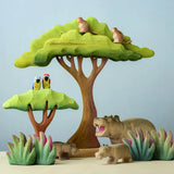 A playscene using Bumbu toys handcrafted wooden trees, grass, monkey, parrots and hippo animal figures