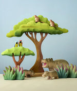 A playscene using Bumbu toys handcrafted wooden trees, grass, monkey, parrots and hippo animal figures