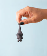 Bumbu Toys Wooden bat figure hanging upside down and held in an adult's hand to show scale.  Fab halloween small world play  handmade toys, full range available at babipur