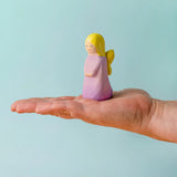 Adult hand holding the Bumbu wooden lavender fairy figure showing scale