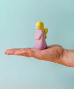 Adult hand holding the Bumbu wooden lavender fairy figure showing scale