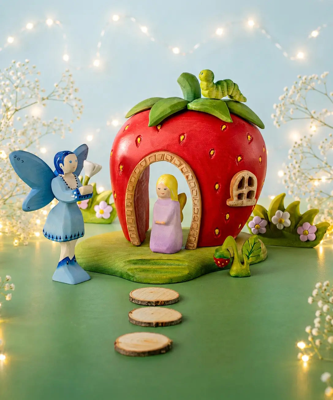 Bumbu handcrafted wooden lavender fairy figure standing in the strawberry house doorway with a blue fairy figure outside 