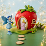 Bumbu handcrafted wooden lavender fairy figure standing in the strawberry house doorway with a blue fairy figure outside 