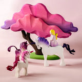 Bumbu wooden pink fairy figure standing on top of a white unicorn next to small pink unicorns and blossom tree figures