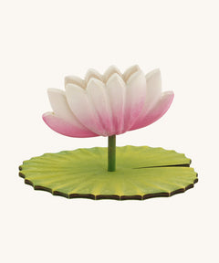 A Hand Crafted and Hand Painted Large Bumbu Wooden Lotus Flower. The figure has a pink and white Lotus Flower with a green stalk and green base, which has been handmade and hand painted, pictured on a plain background 
