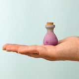 Bumbu handcrafted wooden magic potion decorative figure on a adult hand showing scale