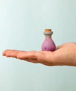 Bumbu handcrafted wooden magic potion decorative figure on a adult hand showing scale