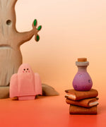 Bumbu handcrafted wooden magic purple potion decorative figure in a halloween scene including a spooky tree, ghost and book figures