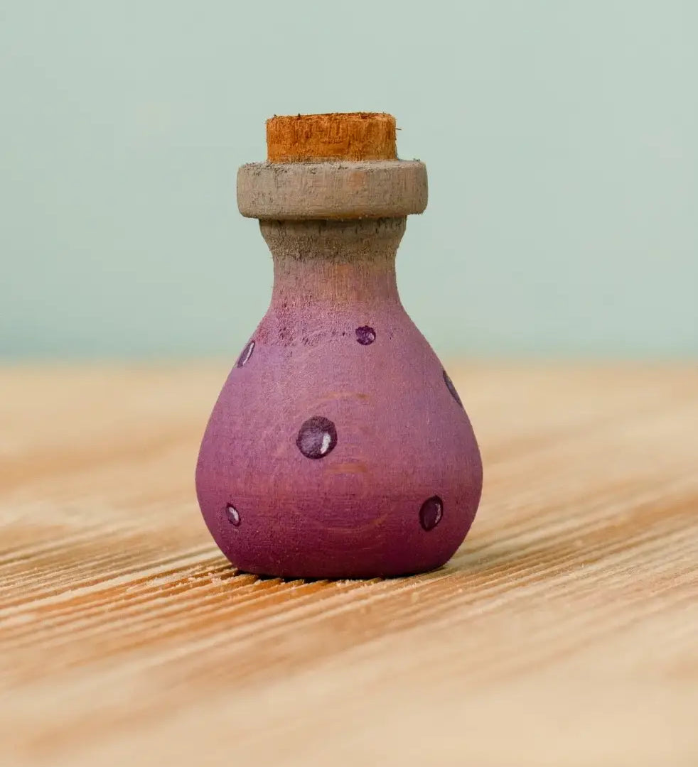 Bumbu handcrafted wooden magic potion decorative figure. A purple flask with painted detail