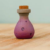Bumbu handcrafted wooden magic potion decorative figure. A purple flask with painted detail