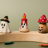 Bumbu handcrafted wooden magic red candle displayed on a celebration ring in between a spooky ghost and mushroom figure