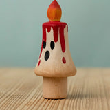 Bumbu handcrafted wooden magic candle with a friendly face and painted red dripping wax