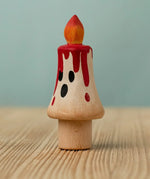 Bumbu handcrafted wooden magic candle with a friendly face and painted red dripping wax