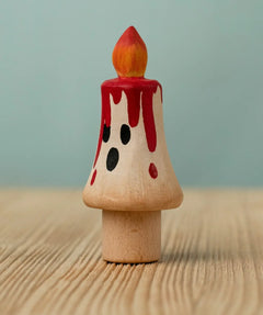 Bumbu handcrafted wooden magic candle with a friendly face and painted red dripping wax