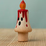 Bumbu handcrafted wooden magic candle with a friendly face and painted red dripping wax