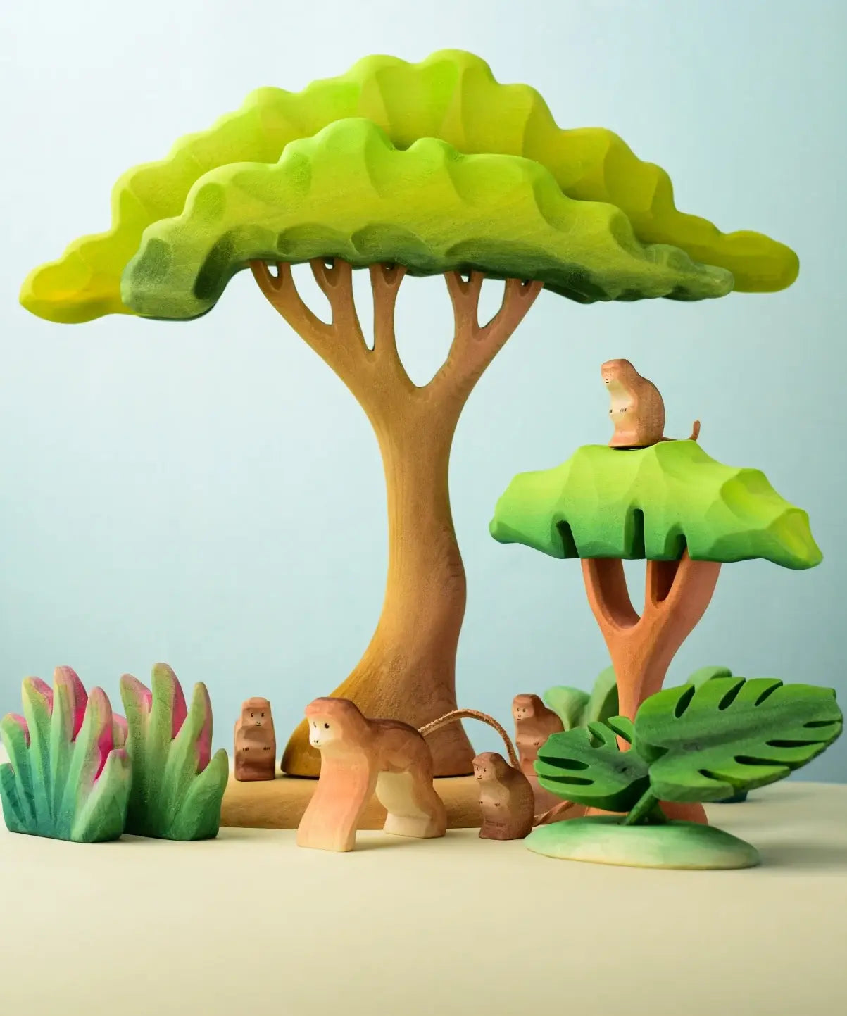 A playscene using Bumbu toys handcrafted wooden trees, grass and monkey figures