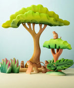 A playscene using Bumbu toys handcrafted wooden trees, grass and monkey figures