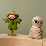 Bumbu handcrafted wooden enchanted mummy decorative figure next to a scarecrow figure displayed on a celebration ring