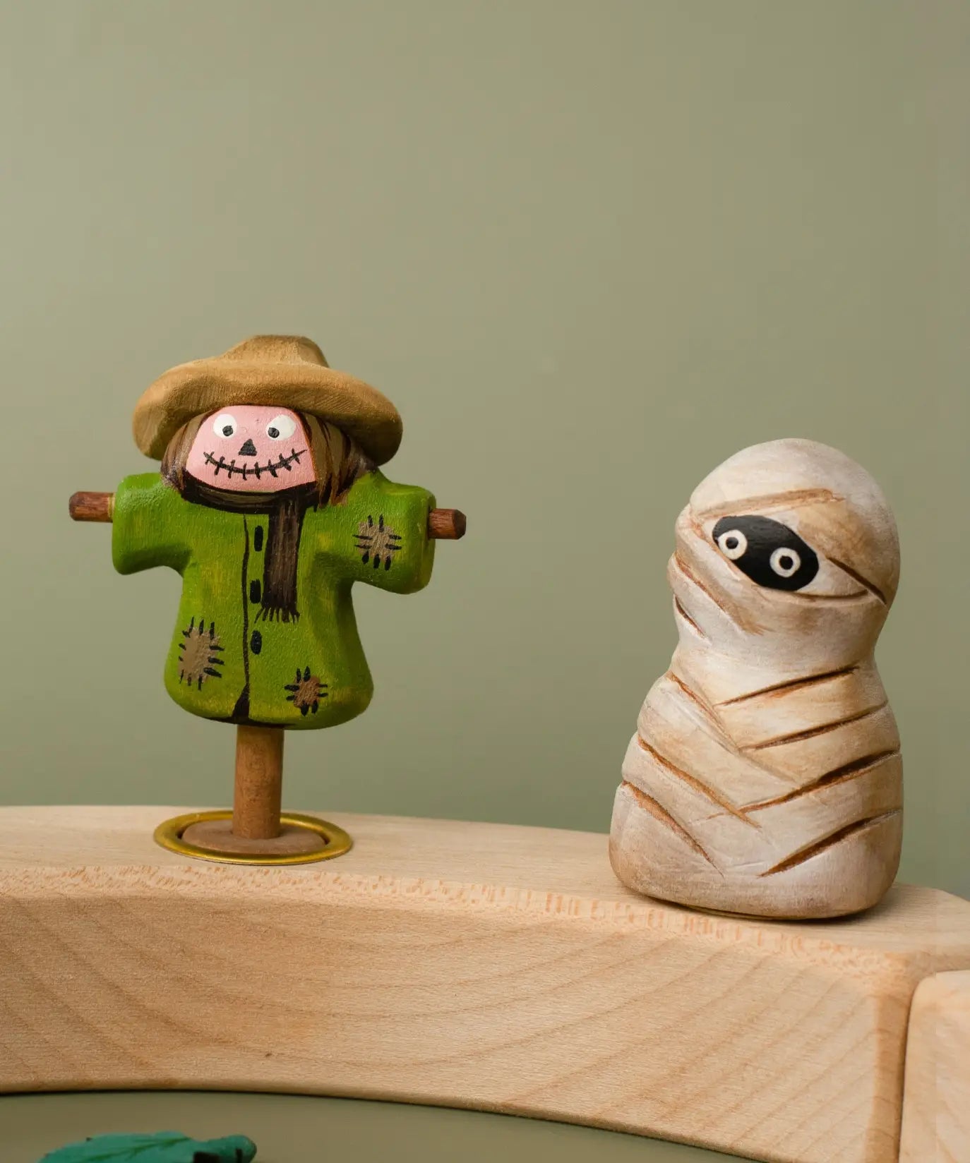 Bumbu handcrafted wooden enchanted mummy decorative figure next to a scarecrow figure displayed on a celebration ring