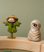 Bumbu handcrafted wooden enchanted mummy decorative figure next to a scarecrow figure displayed on a celebration ring