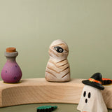 Bumbu handcrafted wooden enchanted mummy decorative figure displayed on a celebration ring next to a potion and ghost wizard figure