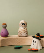Bumbu handcrafted wooden enchanted mummy decorative figure displayed on a celebration ring next to a potion and ghost wizard figure