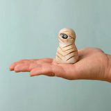 Bumbu handcrafted wooden enchanted mummy decorative figure on an adult hand showing scale