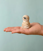 Bumbu handcrafted wooden enchanted mummy decorative figure on an adult hand showing scale