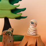 Bumbu handcrafted enchanted mummy decorative figure displayed on a tree stump figure next to a spooky small tree