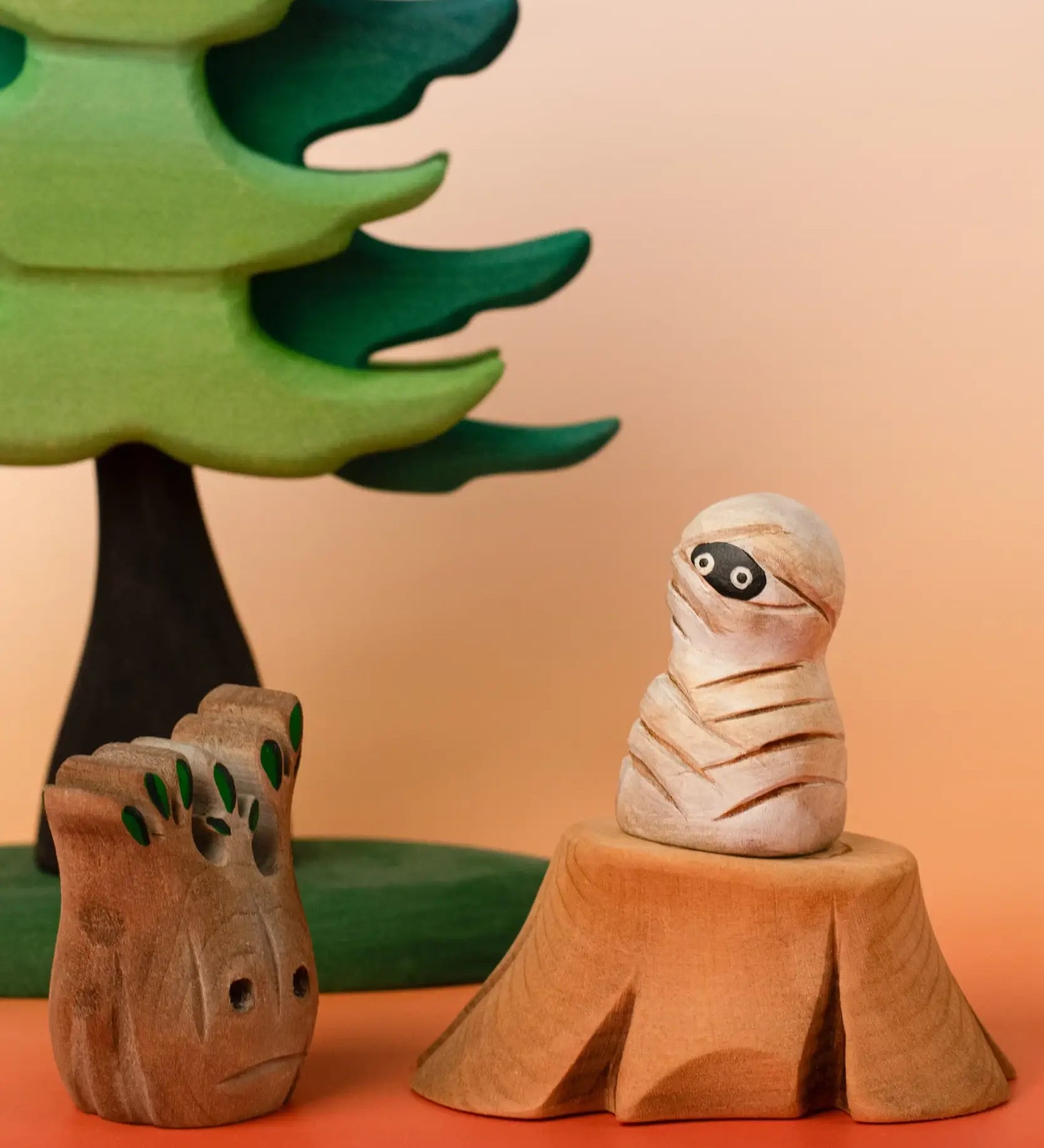 Bumbu handcrafted enchanted mummy decorative figure displayed on a tree stump figure next to a spooky small tree