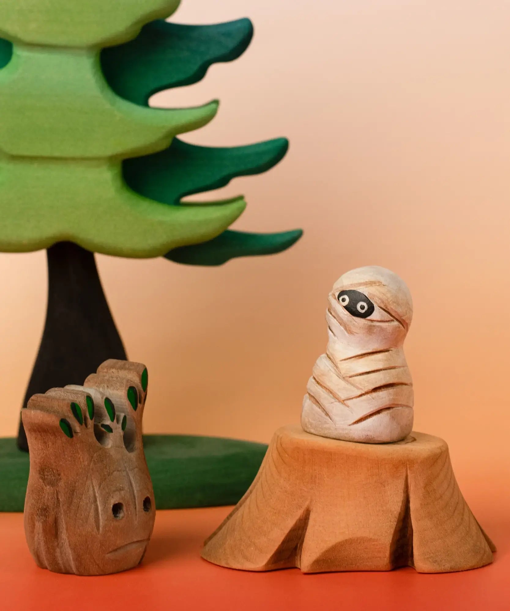 Bumbu handcrafted enchanted mummy decorative figure displayed on a tree stump figure next to a spooky small tree