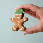 A hand holding the Bumbu gingerbread cookie boy