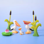 Bumbu Toys Eating Pelican, Pelican Chick and Pelican, all in a scene with Bumbu Cattails and Lilypads